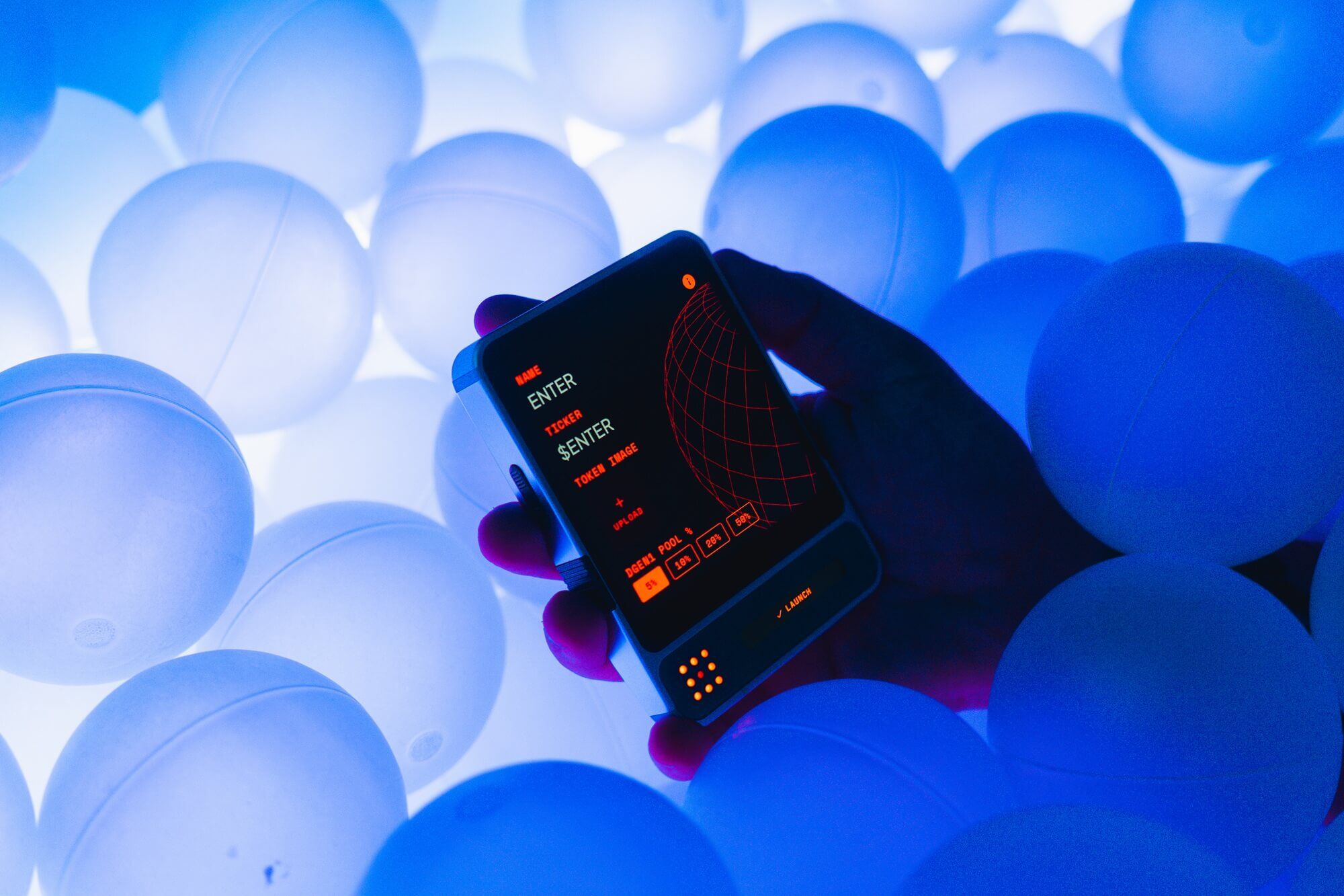 dGEN1 device held among glowing orbs showing token launch interface